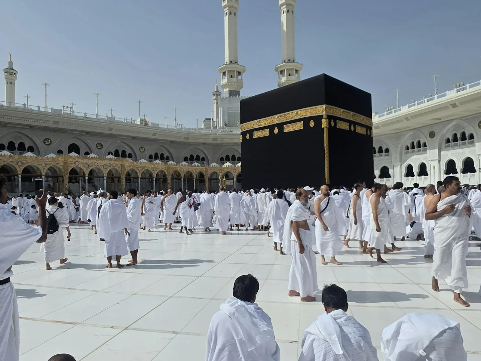 Pilgrims in white robes gather around the kaaba in mecca Pilgrims in white robes gather around the kaaba in mecca